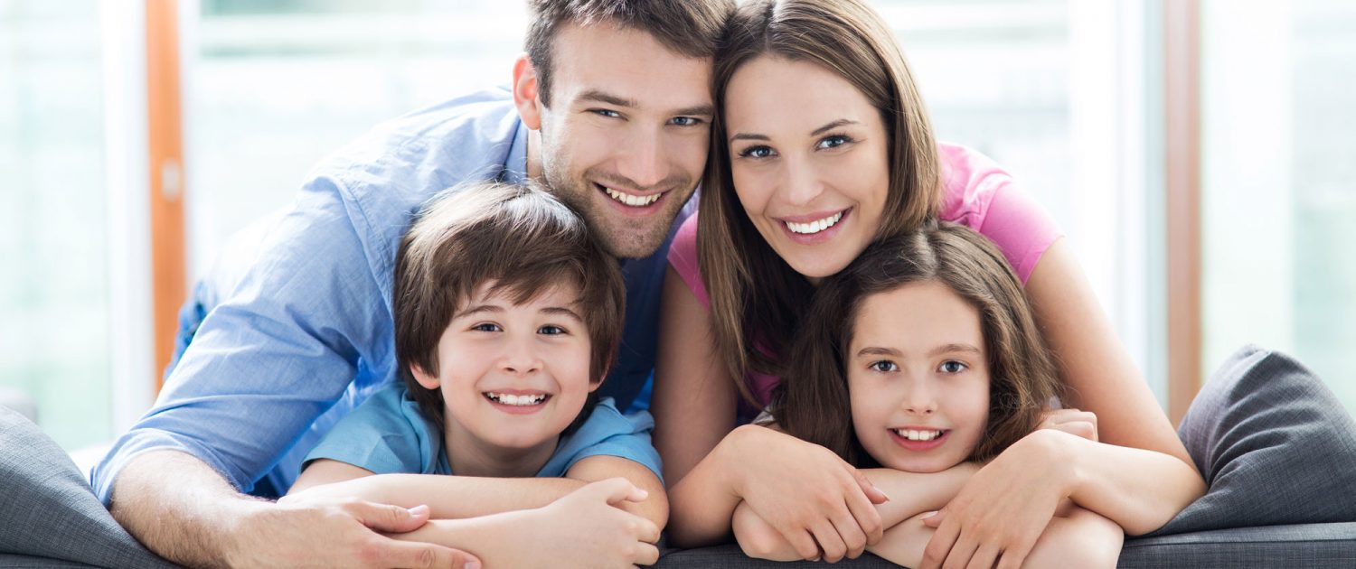 A man, woman and two kids smiling